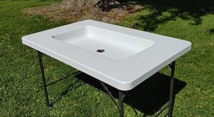 Perfect outdoor companion: Old Cedar Outfitters Fill and Chill Ice Cooler folding table with large sink & drain for cleaning fish and game, plus serving shelf. Stay organized at parties, camping trips or in the wild.
