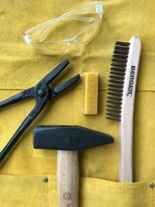 Discover the ultimate blacksmithing starter kit from Hammer & Tongs. Includes hammer, tongs, leather apron, safety glasses, beeswax, and steel brush. Perfect for beginners and professionals alike!